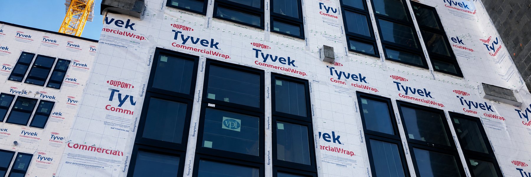 Fațada unei clădiri în execuție, învelită în membrană DuPont Tyvek CommercialWrap